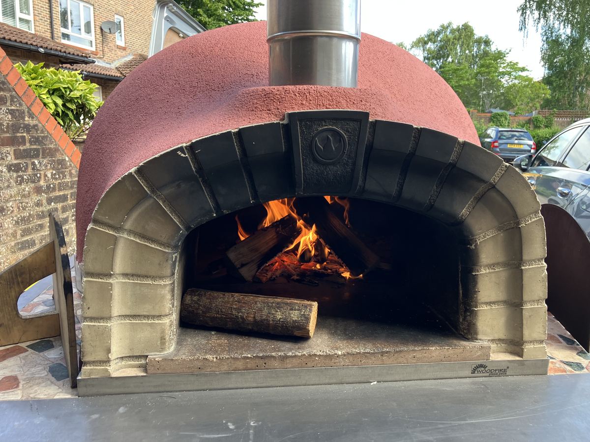 Wood-fired pizza oven with flames burning inside the chamber