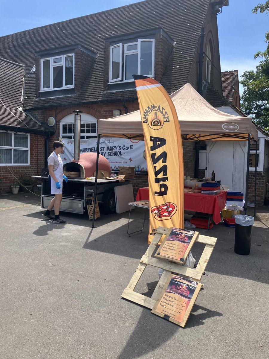 Pizza catering stall with feather flag and oven trailer at a school event
