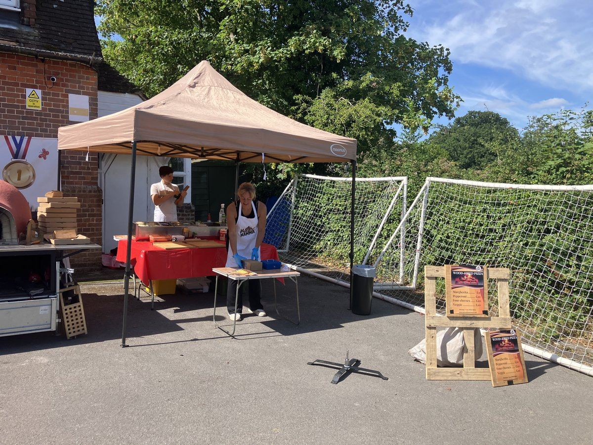 Pizza stall with gazebo and oven trailer beside a sports pitch