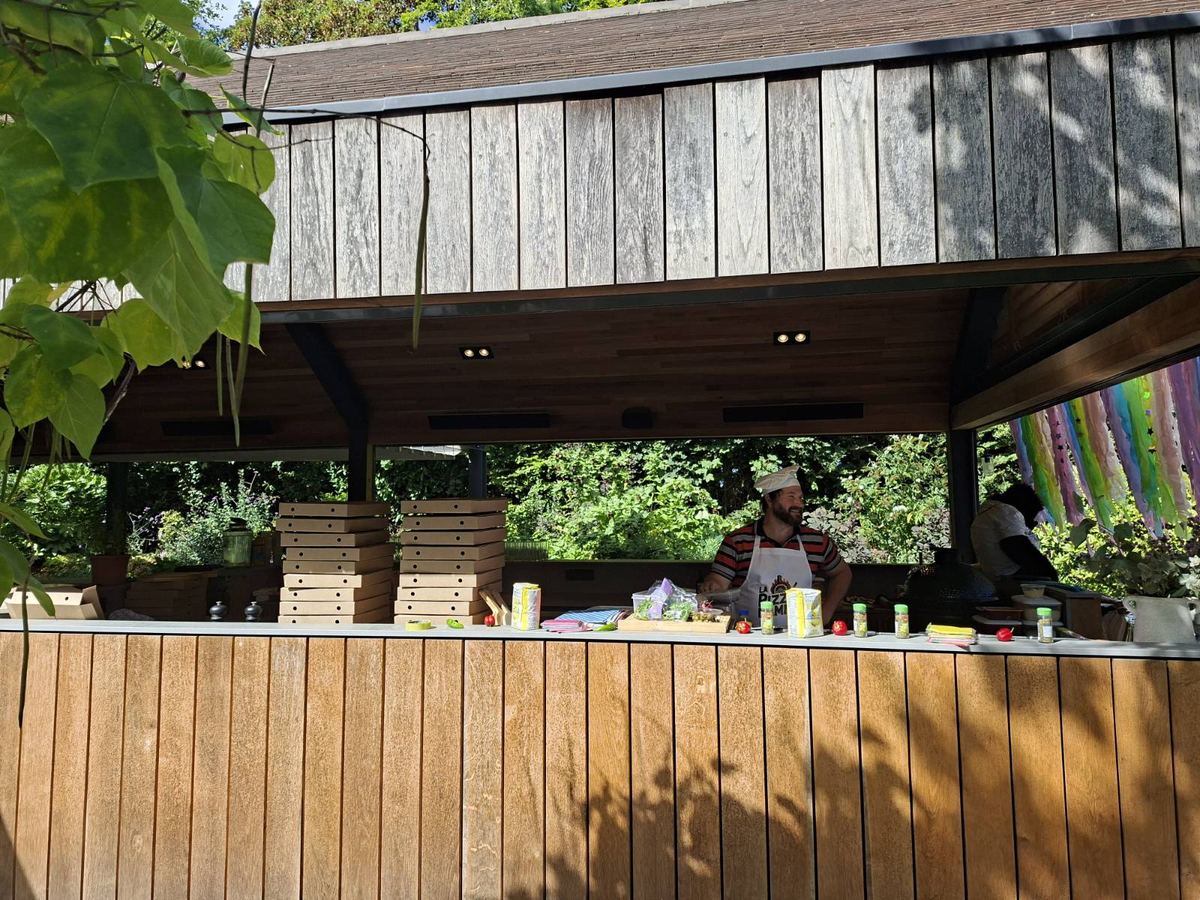 Wooden pizza stall with chef at work in a private garden